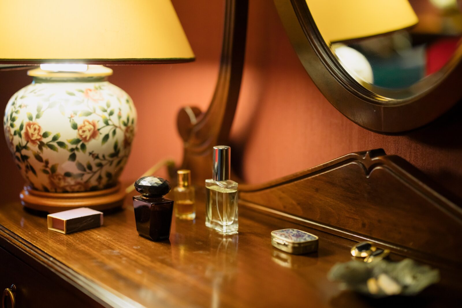Glass perfume bottles on dressing table next to lamp