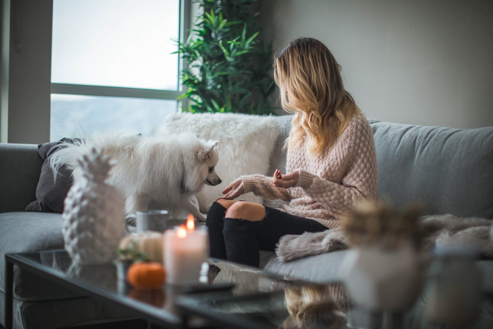 Lady on sofa with dog and candle